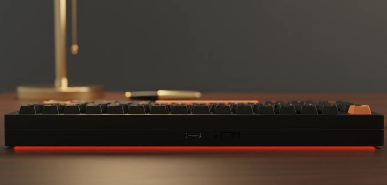 Mechanical keyboard with red accents on a wooden surface